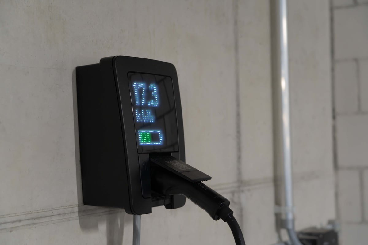 Vom Solarteur installierte Wallbox-Ladestation mit eingestecktem Ladekabel in einer Garage