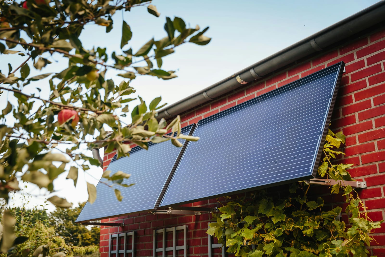 Vom Solarteur montierter Solarthermie-Kollektor an der Ziegelfassade eines Hauses