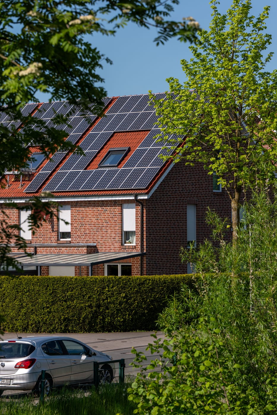 Reihenhauszeile mit Photovoltaikmodulen, die der Solarteur auf den Satteldächern montiert hat